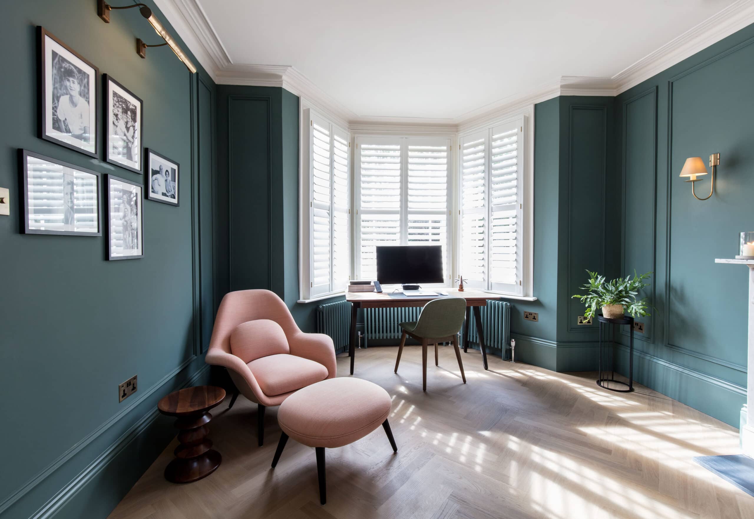 Luxury living room designed by Randa Kort Interior Design in St Albans, Hertfordshire, Traditional green panelled study in a St Albans period home, with plantation shutters, restored marble fireplace and a desk set into the bay window.