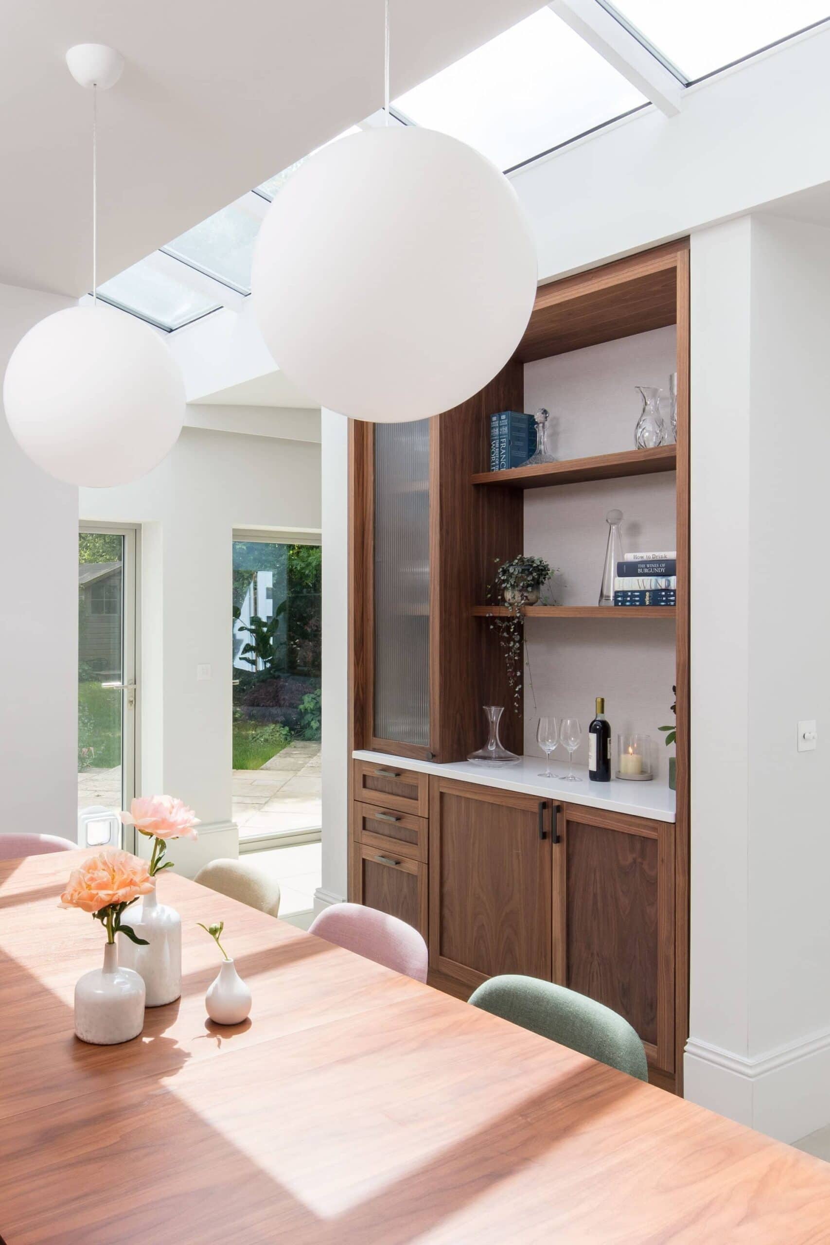 Bespoke walnut dining cabinet with fluted glass door and open shelving in a St Albans open plan kitchen and dining renovation.