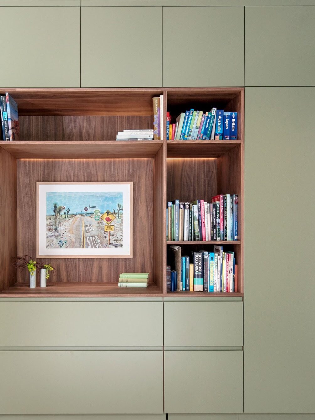 Bespoke sage green study with a built in walnut desk and colourful artwork in a St Albans home renovation. Designed by Randa Kort